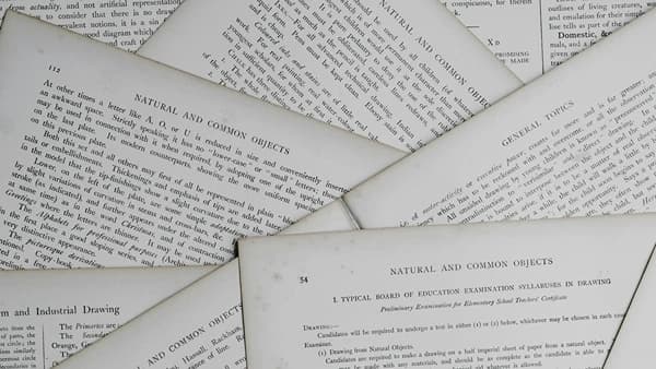 Páginas superpuestas de libros antiguos con títulos sobre educación y dibujo técnico.