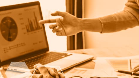 Reunión de trabajo con análisis de datos en un portátil.”